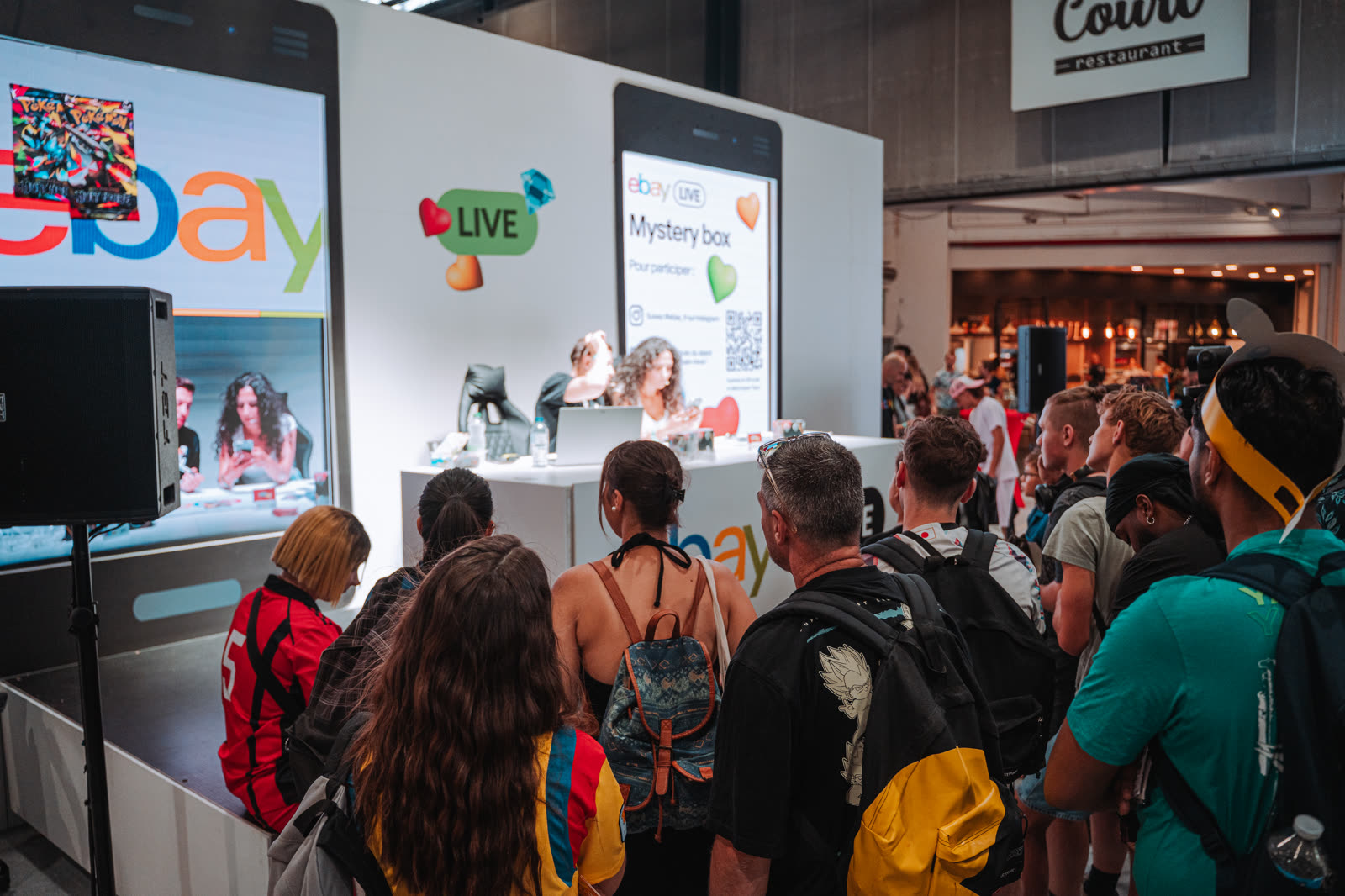 Visitors gathered around the eBay live show in the TCG Universe area